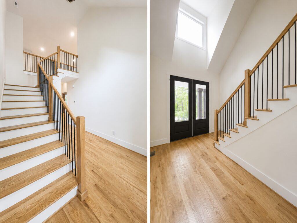 Split view of a grand two-story foyer showcasing a classic wooden staircase with iron balusters on the left, and striking black double entry doors under a vaulted ceiling on the right, crafted by Travars Built Homes.