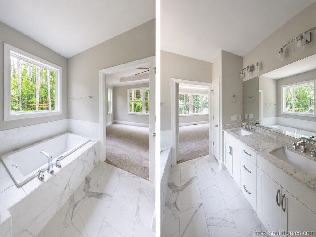 Dual-angle view of a bright primary bathroom showcasing a white drop-in soaking tub with a marble-style tile surround on the left, and a long white double vanity with quartz countertops on the right, built by Travars Built Homes.