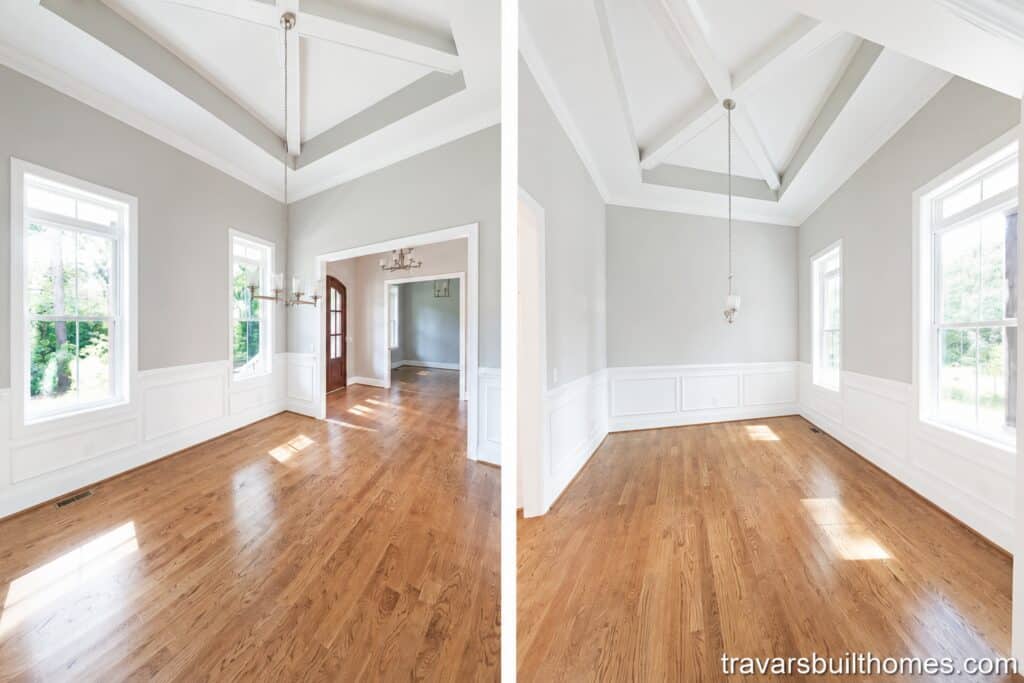 Dual-angle view of a custom formal dining room showcasing classic white wainscoting, an impressive vaulted ceiling with exposed cross beams, and seamless hardwood floors flowing throughout, designed by Travars Built Homes.