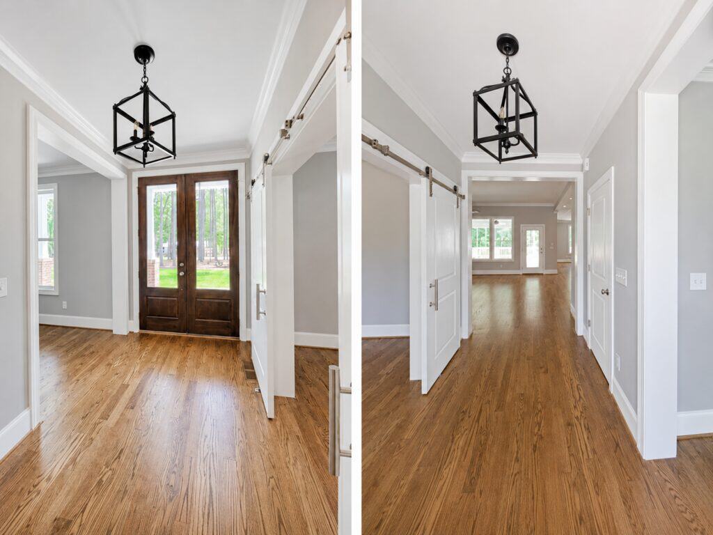Split perspective of a bright custom front entry foyer highlighting rich oak wood floors, a dark double front door on the left, and a classic geometric black lantern pendant light on the right, by Travars Built Homes.